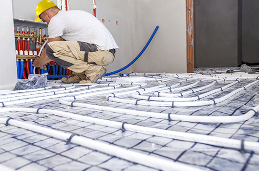 Installation d'un plancher chauffant par un technicien Eco Solutions